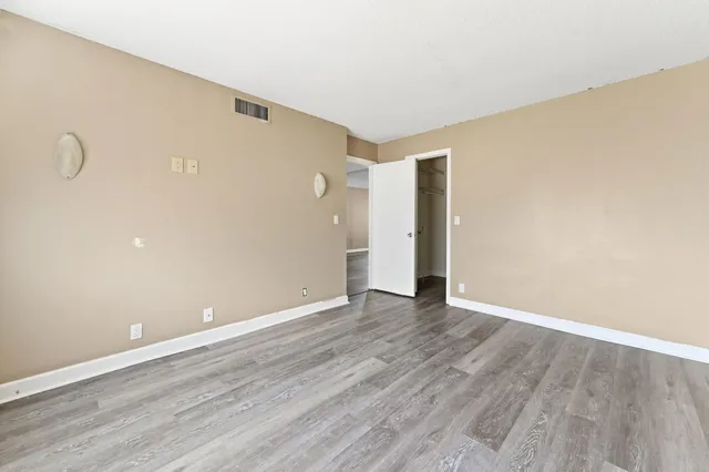 a view of an empty room with wooden floor