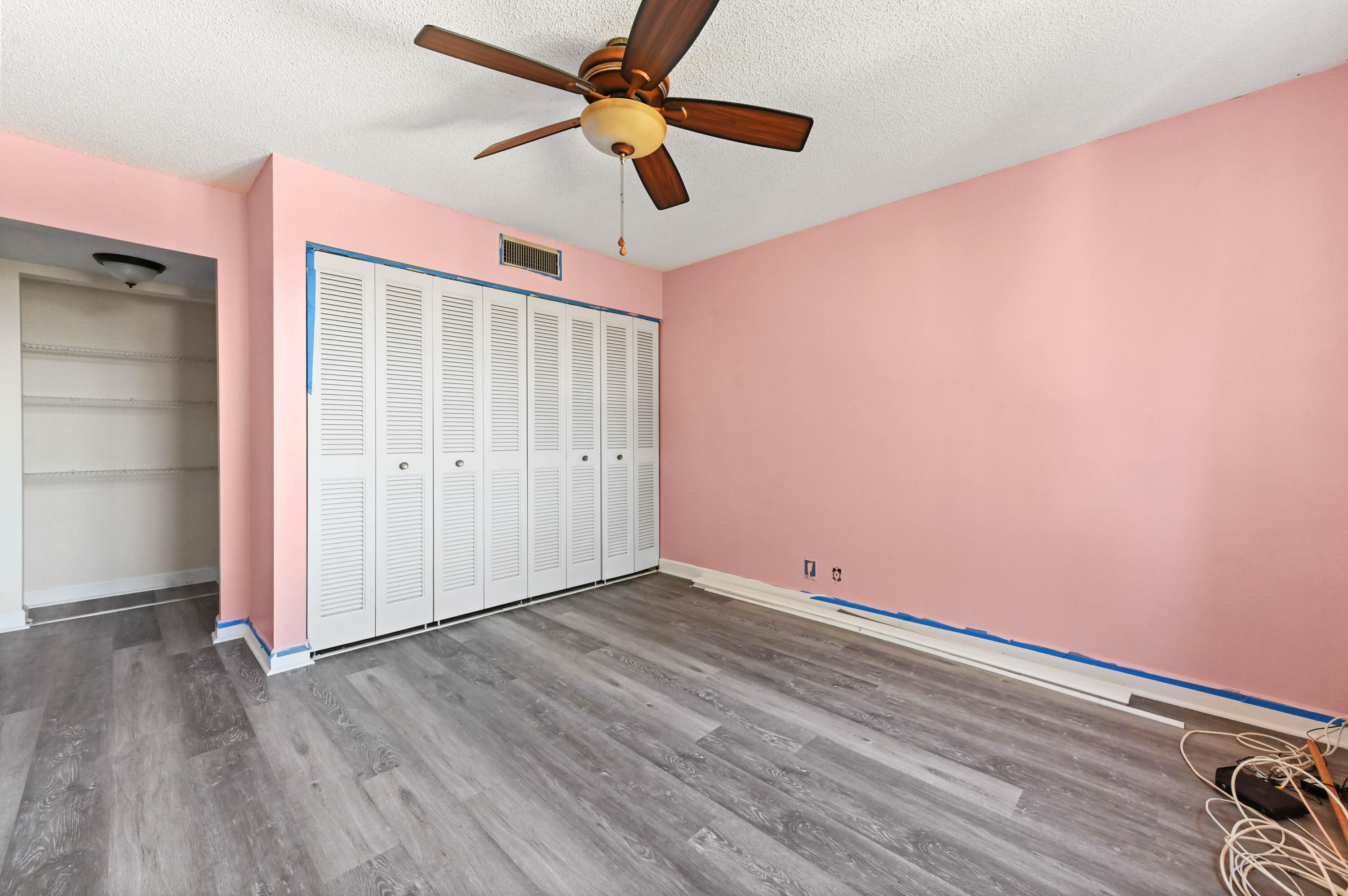 4080 Tivoli Court, Unit 202 Lake Worth, FL 33467 - Photo 23 of 28 an empty room with wooden floor fan and windows