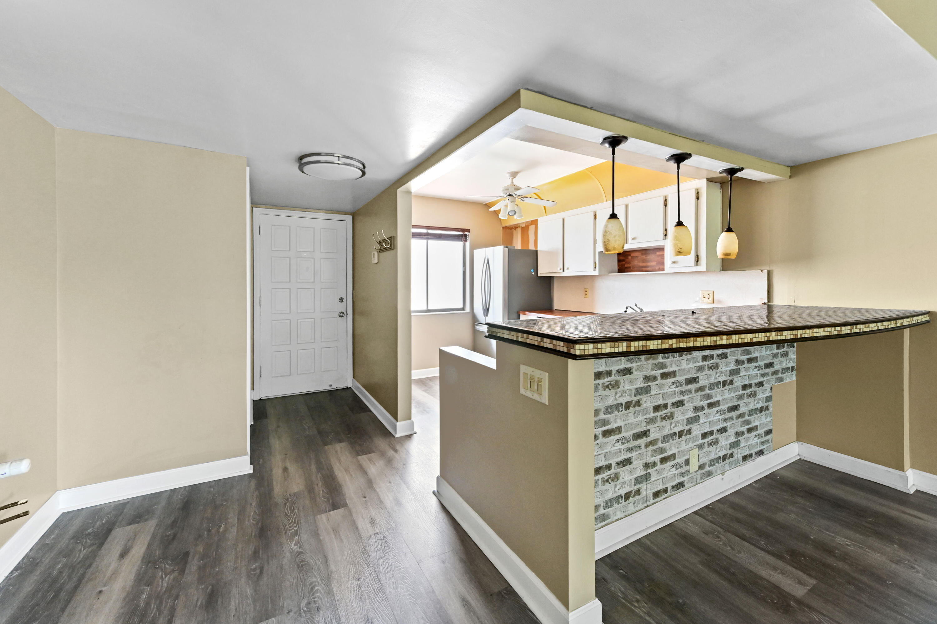 4080 Tivoli Court, Unit 202 Lake Worth, FL 33467 - Photo 6 of 28 a kitchen with kitchen island a sink appliances and a large window