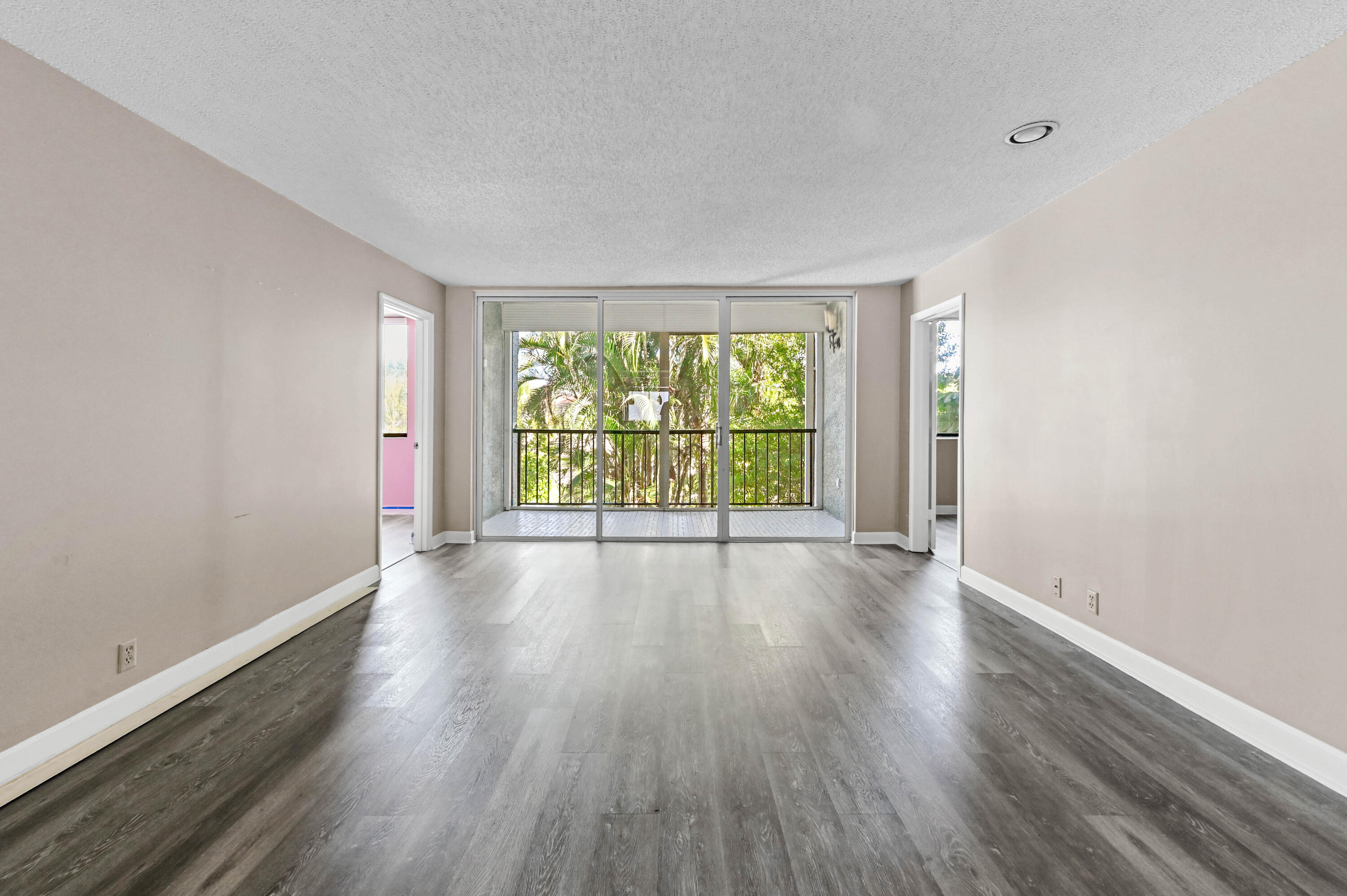4080 Tivoli Court, Unit 202 Lake Worth, FL 33467 - Photo 8 of 28 a view of an empty room with wooden floor and a window