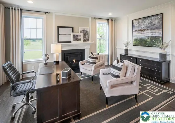 a living room with furniture two windows and a fireplace