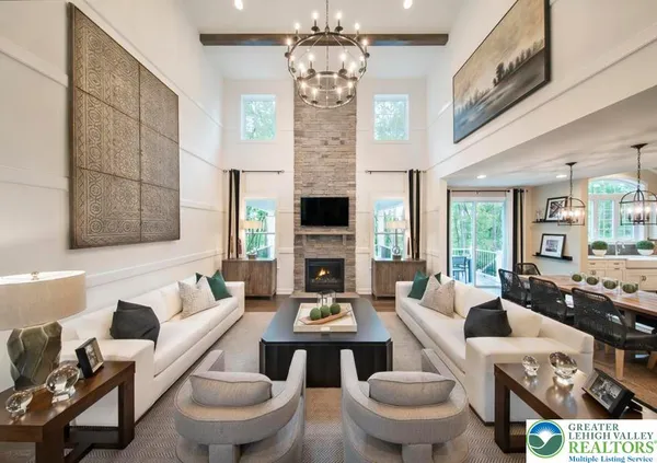 a living room with furniture a fireplace and a chandelier