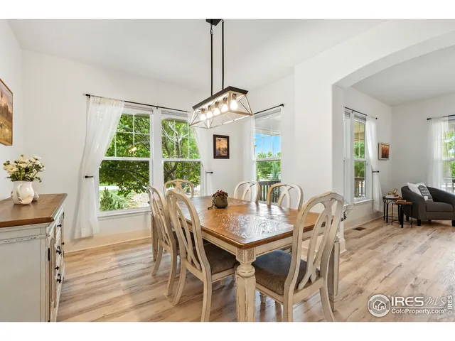 a dining room with furniture a chandelier and wooden floor