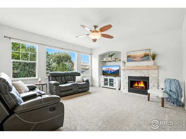 a living room with furniture a fireplace and a large window