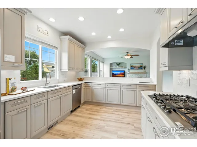 a large kitchen with stainless steel appliances a sink a stove and cabinets