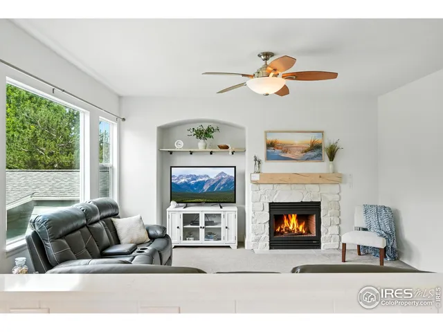 a living room with furniture a fireplace and a window