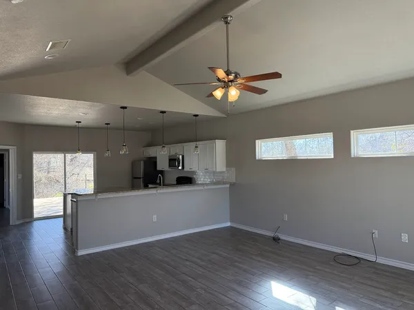 a view of a kitchen with a sink a microwave and a hard wood floor