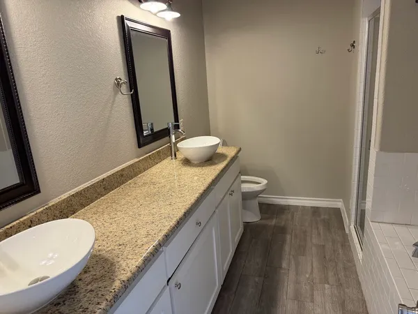 a bathroom with a granite countertop sink toilet and mirror
