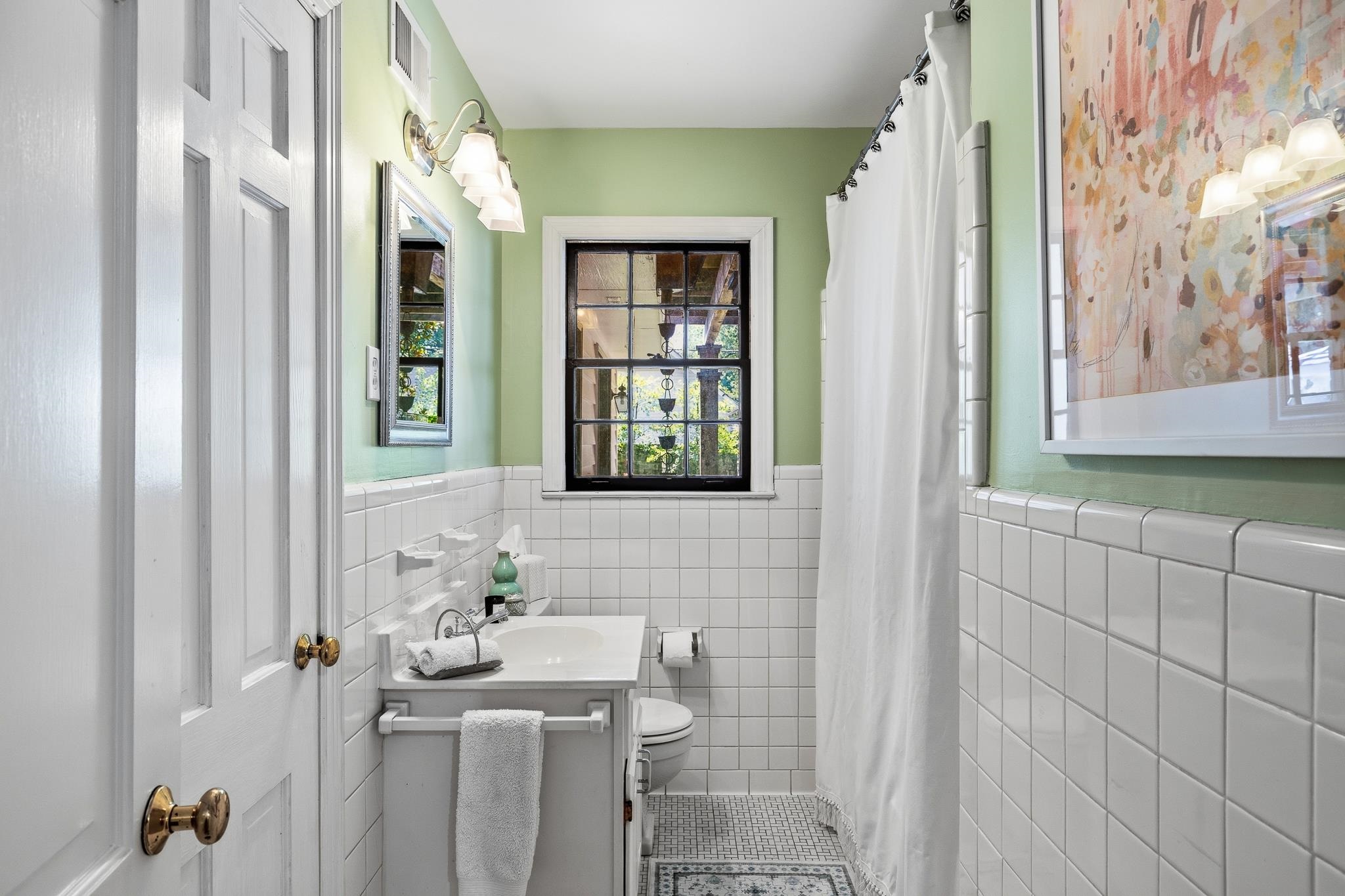 253 Ridgefield Road Memphis, TN 38111 - Photo 25 of 32 Bathroom featuring a white tile wainscoting, light green walls, and a white vanity with an integrated sink