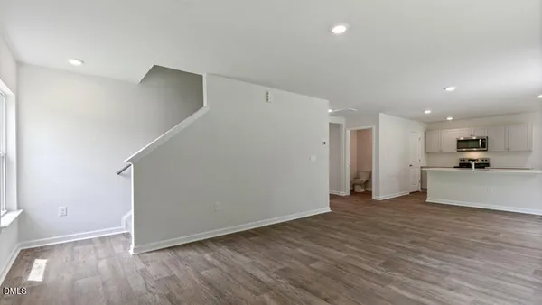 a view of a big room with wooden floor and a kitchen