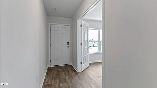 a view of an empty room with closet and a window