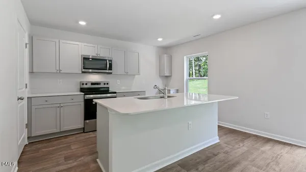a kitchen with kitchen island a sink stainless steel appliances and cabinets