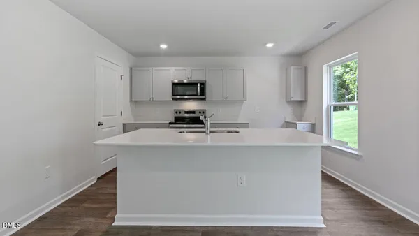 a kitchen with kitchen island a sink stainless steel appliances and window