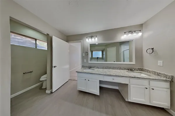 a spacious bathroom with a granite countertop sink and a mirror