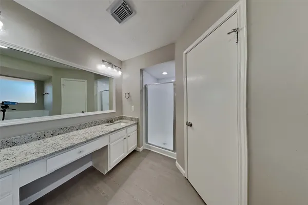 a spacious bathroom with a granite countertop sink and a mirror