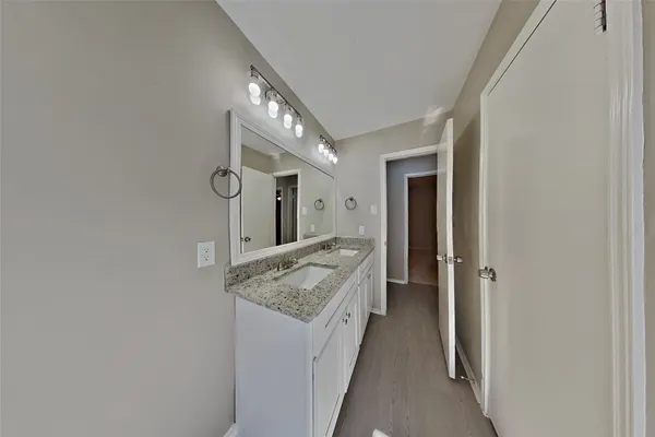 a bathroom with a granite countertop sink and a mirror