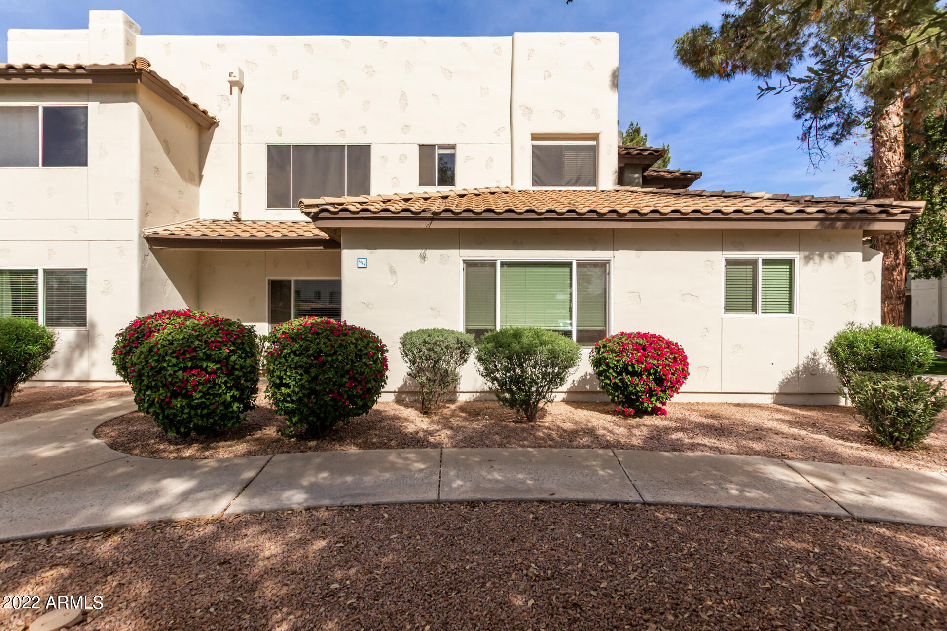 1825 West Ray Road, Unit 1049 Chandler, AZ 85224 - Photo 1 of 28 a view of a house with a yard and potted plants