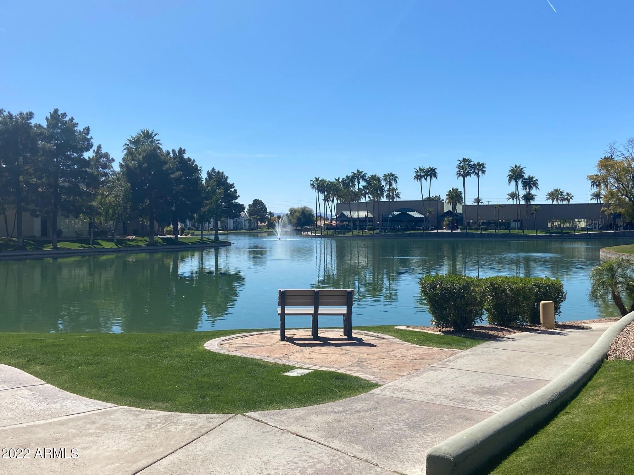 1825 West Ray Road, Unit 1049 Chandler, AZ 85224 - Photo 25 of 28 a view of a lake with a bench and lake view