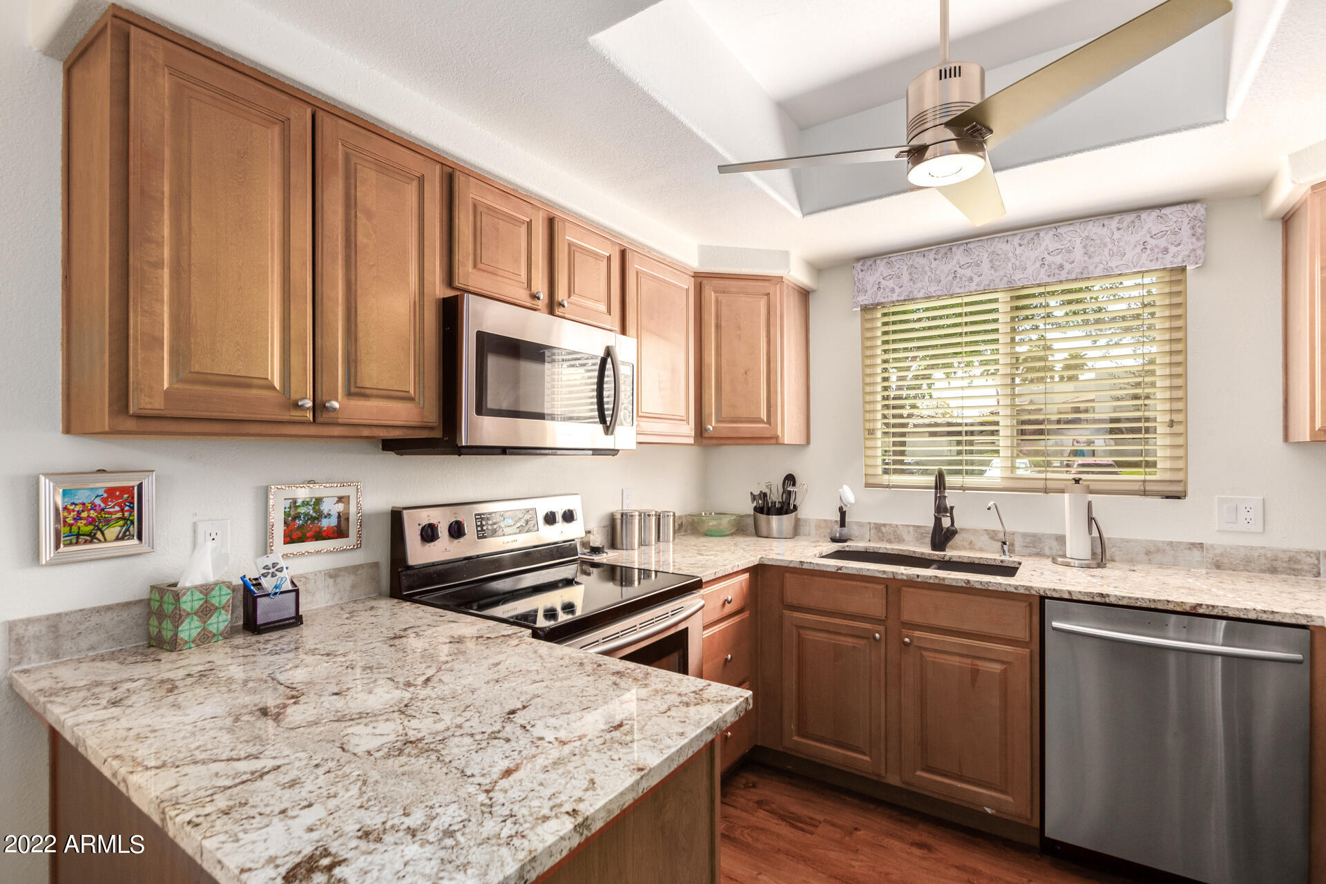 1825 West Ray Road, Unit 1049 Chandler, AZ 85224 - Photo 9 of 28 a kitchen with stainless steel appliances granite countertop a sink stove and microwave