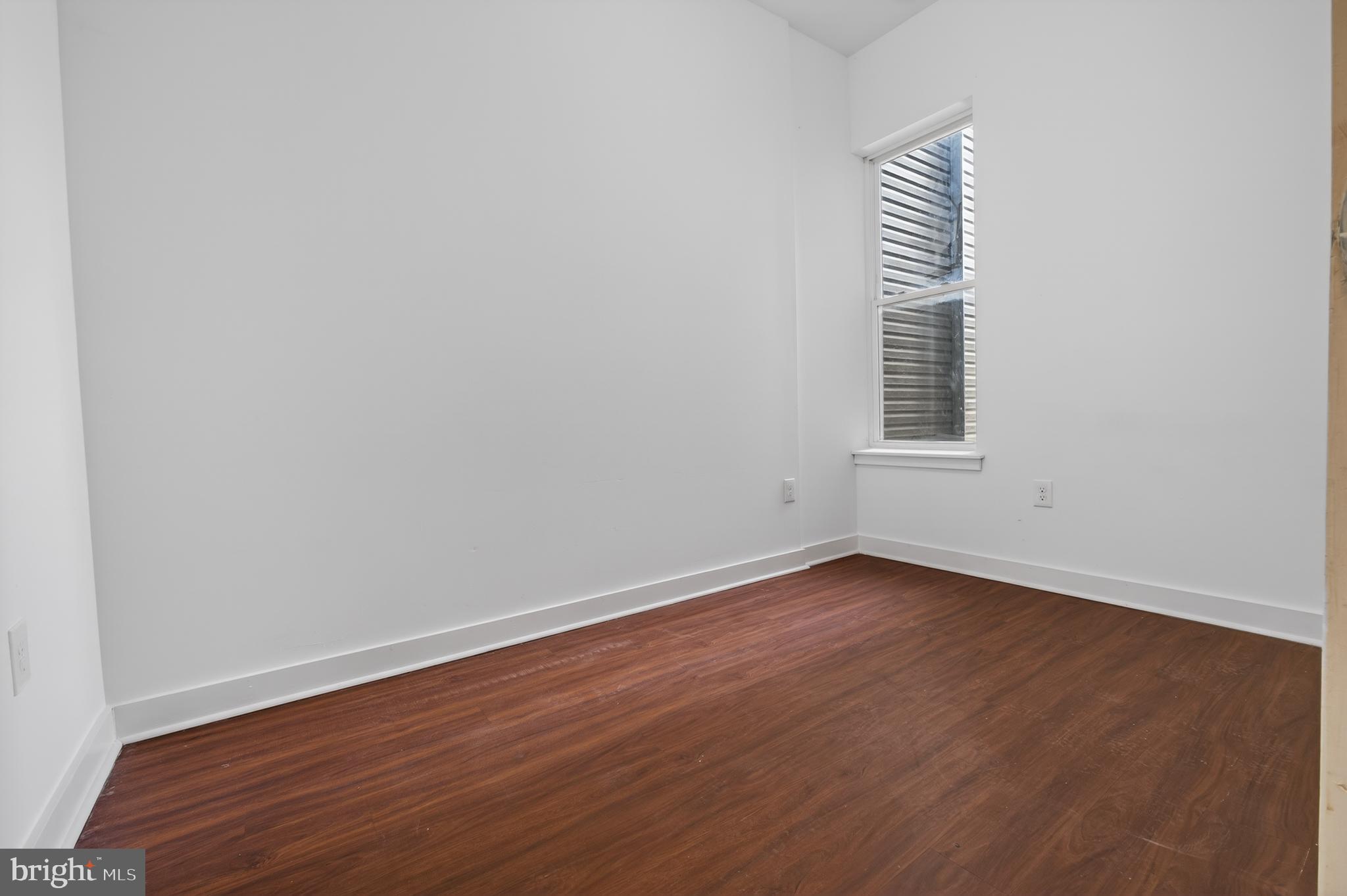 6040 Market Street, Unit 2 Philadelphia, PA 19139 - Photo 6 of 16 an empty room with wooden floor and windows