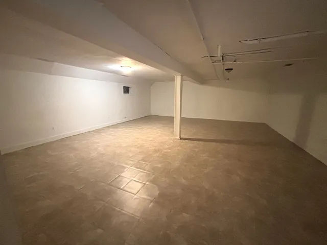 an empty room with a ceiling fan and window