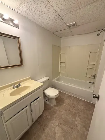 a bathroom with a granite countertop sink toilet a mirror and shower