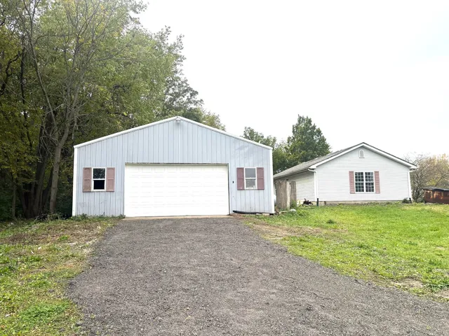 a view of a house with a yard and large tree
