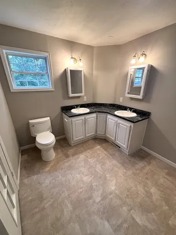 a kitchen with a sink stove and a toilet