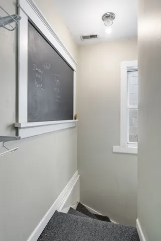 a view of small space with wooden floor and fan