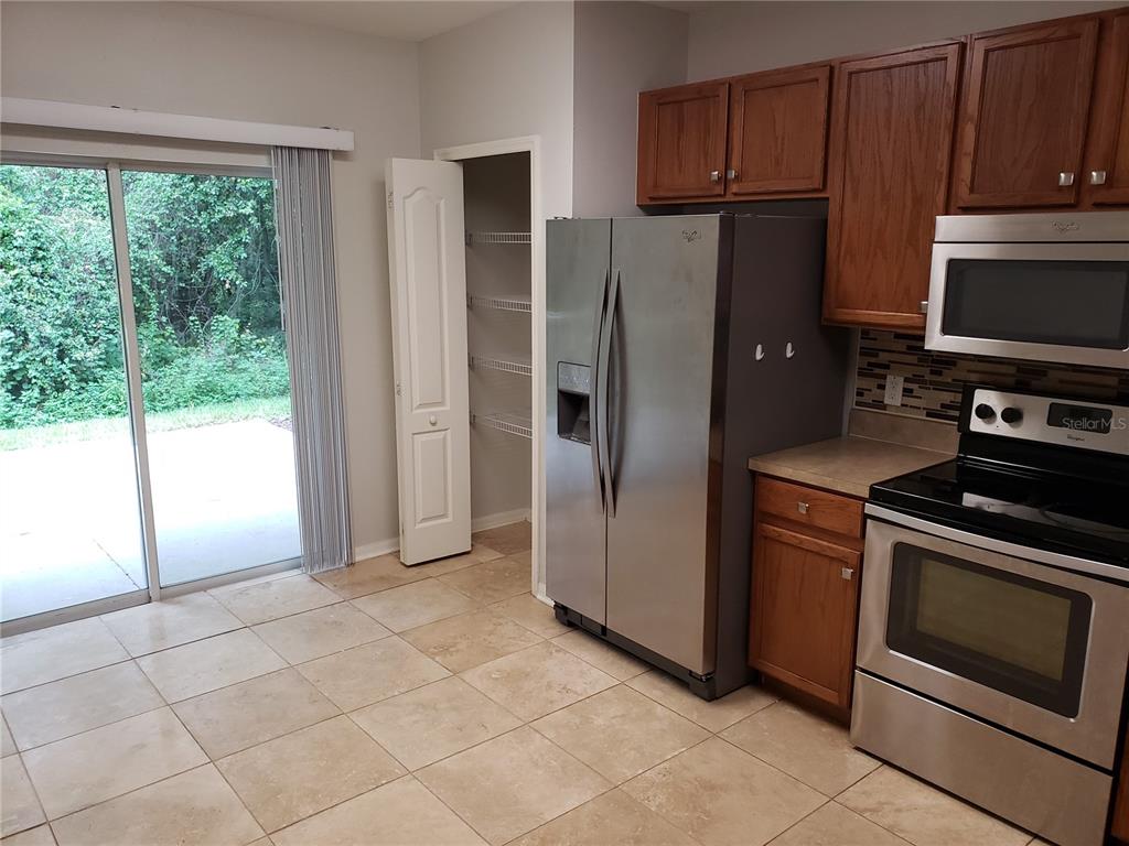 5870 Fishhawk Ridge Drive Lithia, FL 33547 - Photo 11 of 34 a kitchen with a refrigerator stove and cabinets