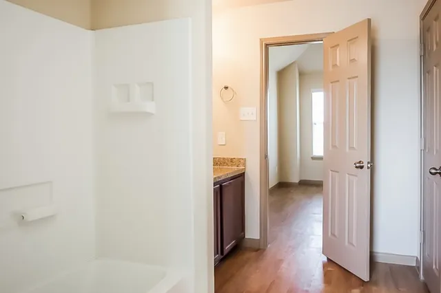 a view of a hallway with wooden floor and closet