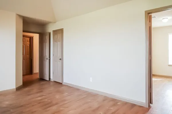 a view of hallway with closet and wooden floor