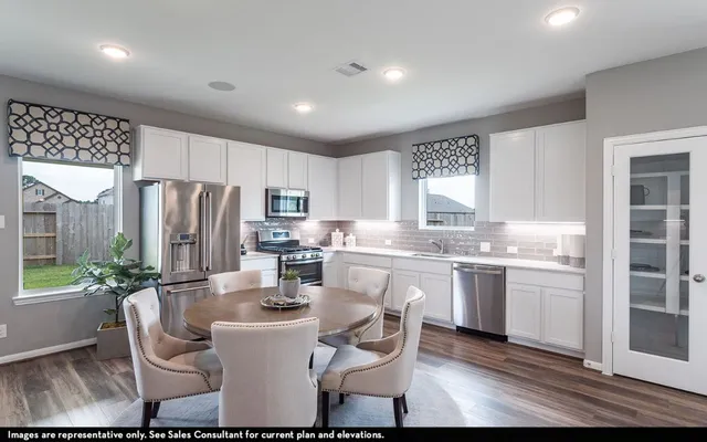 a kitchen with refrigerator and chairs