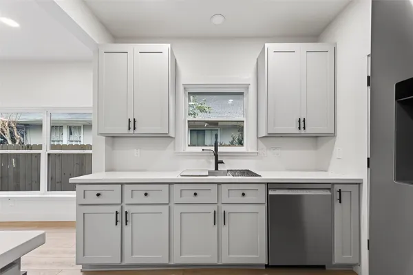 a kitchen with stainless steel appliances white cabinets and a sink
