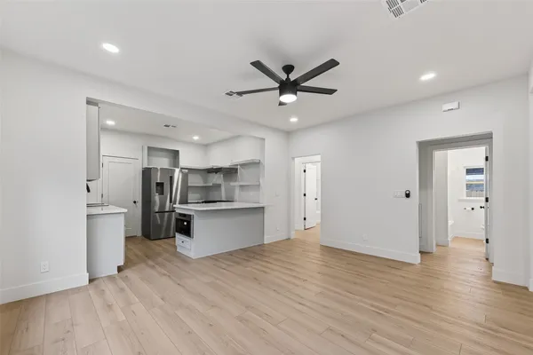 a view of kitchen with stainless steel appliances refrigerator stove microwave and cabinets