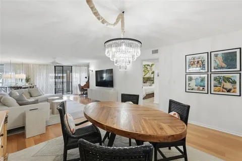 a dining room with furniture a chandelier and window