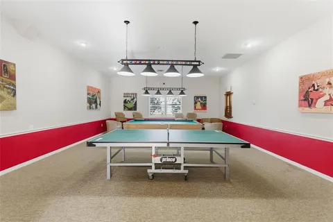 a view of a swimming pool with a lawn chairs and palm tree