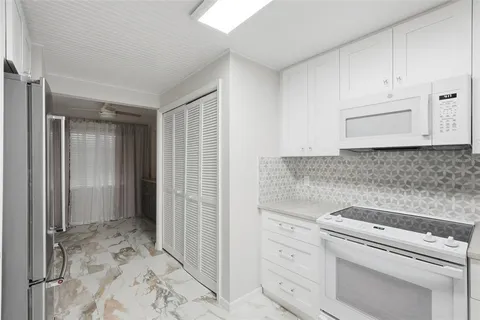 a view of a kitchen with white cabinets