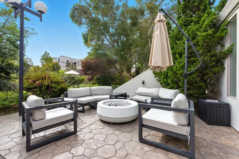 a view of a patio with couches table and chairs and potted plants