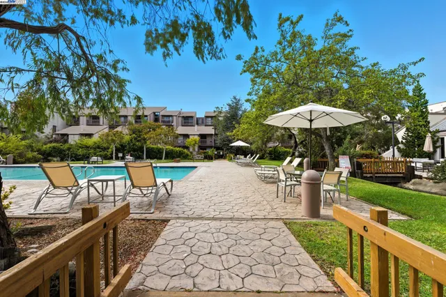 a view of a patio with chairs and a table under an umbrella