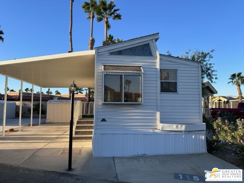 69801 Ramon Road, Unit 115 Cathedral City, CA 92234 - Photo 4 of 13 a front view of a house with glass windows and palm tree