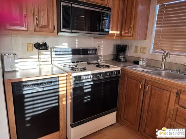 a kitchen with stainless steel appliances granite countertop a stove microwave and sink