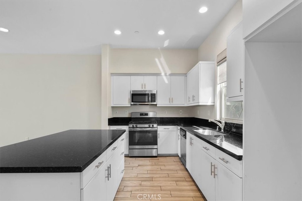 726 Central Avenue Upland, CA 91786 - Photo 11 of 42 a kitchen with granite countertop a sink stove and cabinets