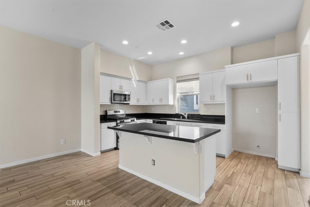 726 Central Avenue Upland, CA 91786 - Photo 10 of 42 a kitchen with stainless steel appliances granite countertop a sink and wooden floor