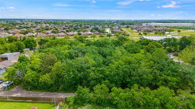 an aerial view of residential building with outdoor space and trees all around