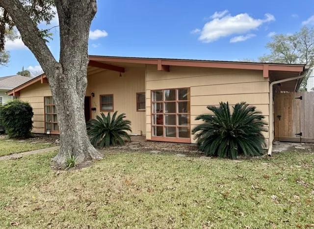 a view of a house with backyard and a tree