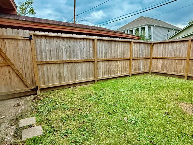 a view of a backyard with wooden fence
