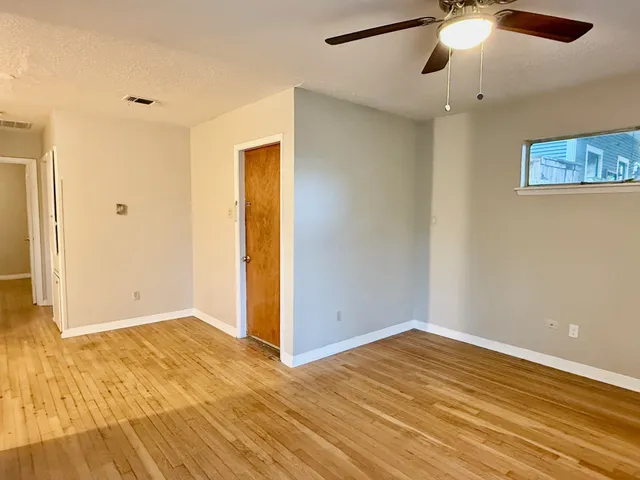 a view of empty room with wooden floor