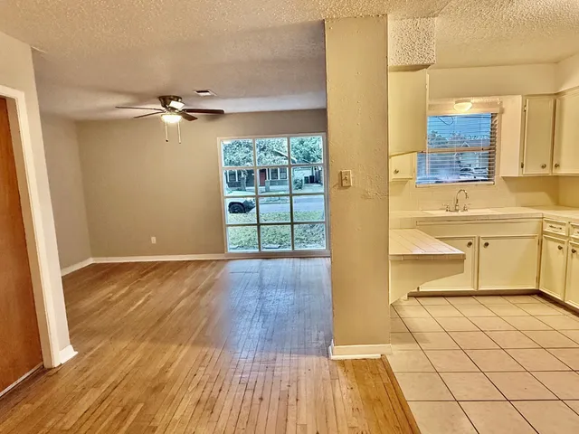 a view of a kitchen with wooden floor and a sink