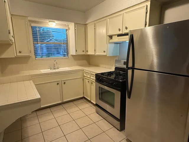a kitchen with stainless steel appliances a refrigerator sink and cabinets